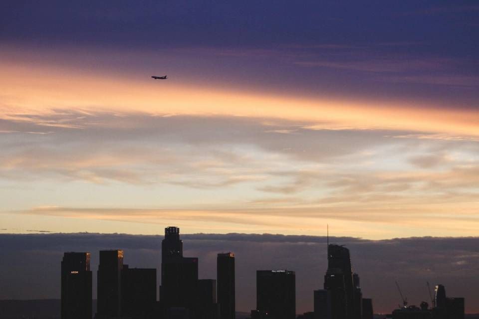 Flugzeug fliegt über eine Skyline hinweg
